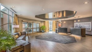 A modern hotel lobby with a reception desk, seating area, and large windows offering views of the outside. - Hampton Inn & Suites Tallahassee Capitol - University (Tallahassee)