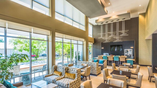 A spacious lobby with comfortable seating, large windows, and a modern chandelier. - Hampton Inn & Suites Tallahassee Capitol - University (Tallahassee)