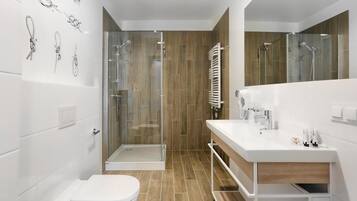A modern bathroom with a shower, toilet, and vanity.