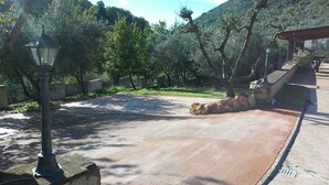 Un sendero pavimentado en un parque con muros de piedra y un farol.