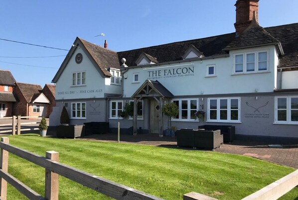Un edificio llamado 'The Falcon' con un letrero que indica que es restaurante, pub de campo y hotel.