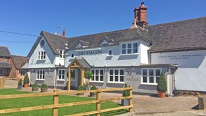 A traditional building with a sign reading "The Falcon Restaurant, Country Pub, Hotel".