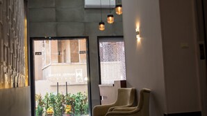 A modern lobby with a staircase, seating area, and a view of the outside. - Marvel Stone Hotel (Giza)