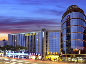A modern hotel with a curved glass facade, a prominent Kingdo Hotel sign, and a Tianbang Expressway sign in the background. - Kingdo Hotel (Zhuhai)