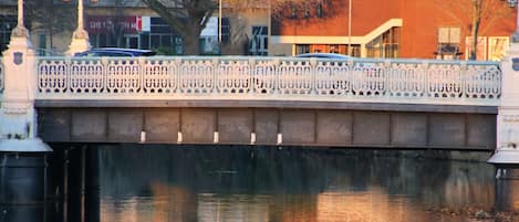 Un puente con barandillas ornamentadas y un edificio con el letrero 'the brewhouse' al fondo.
