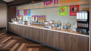 A breakfast counter with various food items and a coffee machine. - Tru by Hilton Farmville (Farmville)