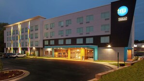 A modern hotel with a prominent 'tru Hilton' sign, multiple floors, and a well-lit entrance. - Tru by Hilton Farmville (Farmville)