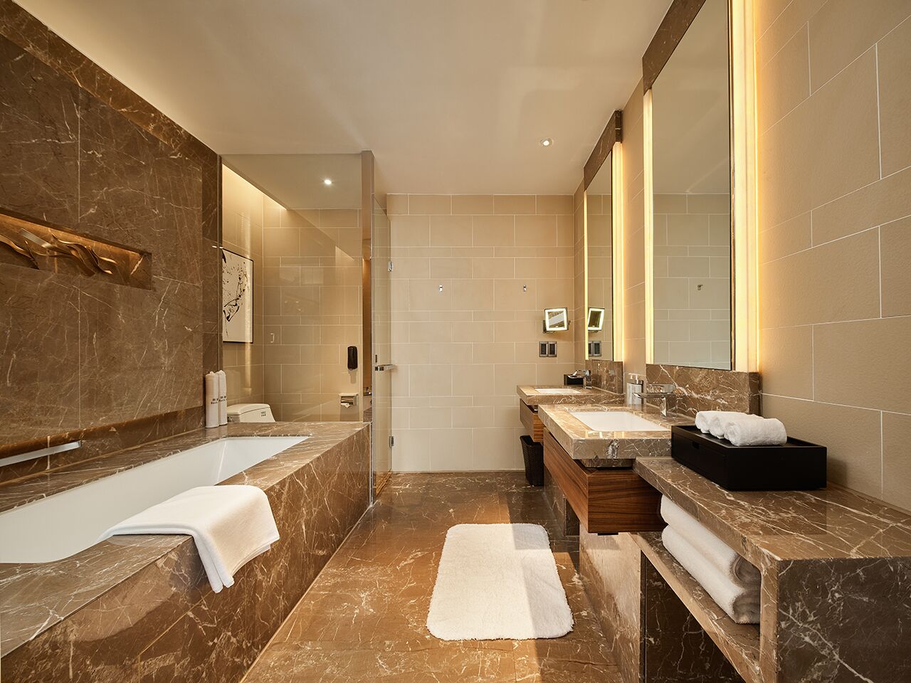 A modern bathroom with a large bathtub, two sinks, and a mirror.