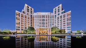 A modern hotel with a symmetrical facade, large windows, and a central entrance. - HUALUXE Ningbo Harbor City by IHG (Ningbo)
