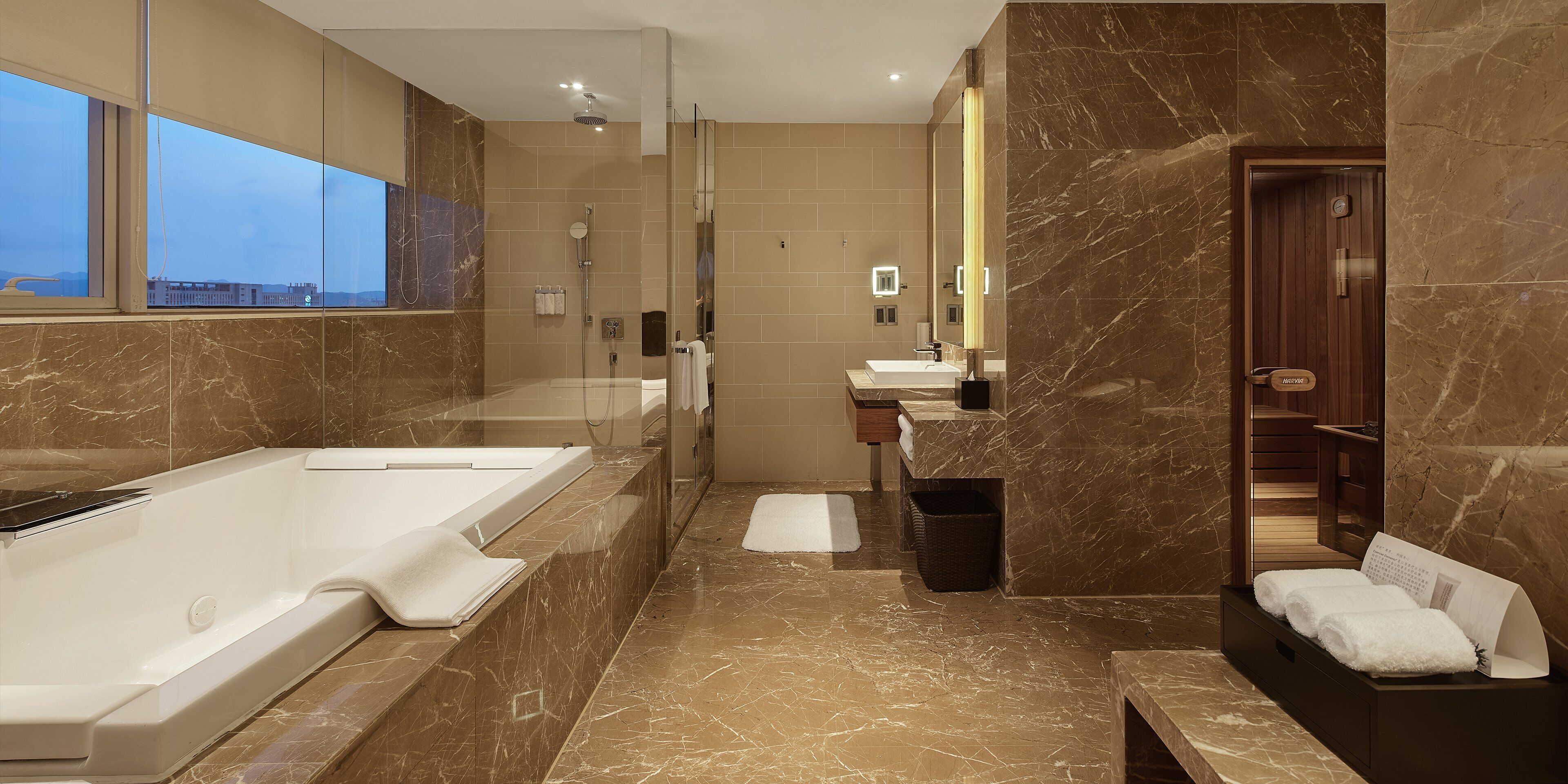 A modern bathroom with a large bathtub, a shower, and a vanity with a mirror.
