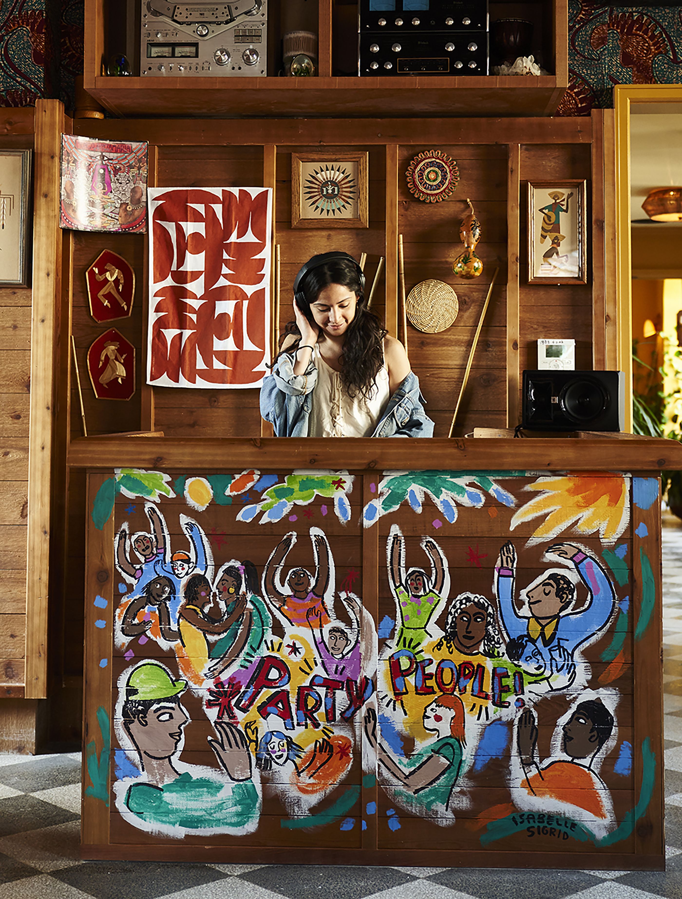 A wooden reception desk with a colorful mural depicting people celebrating.