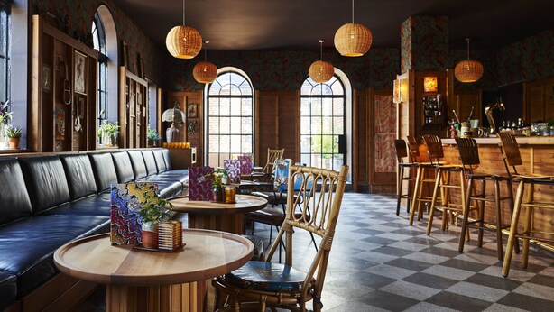 Un restaurant avec un sol à carreaux, des meubles en bois et de grandes fenêtres.