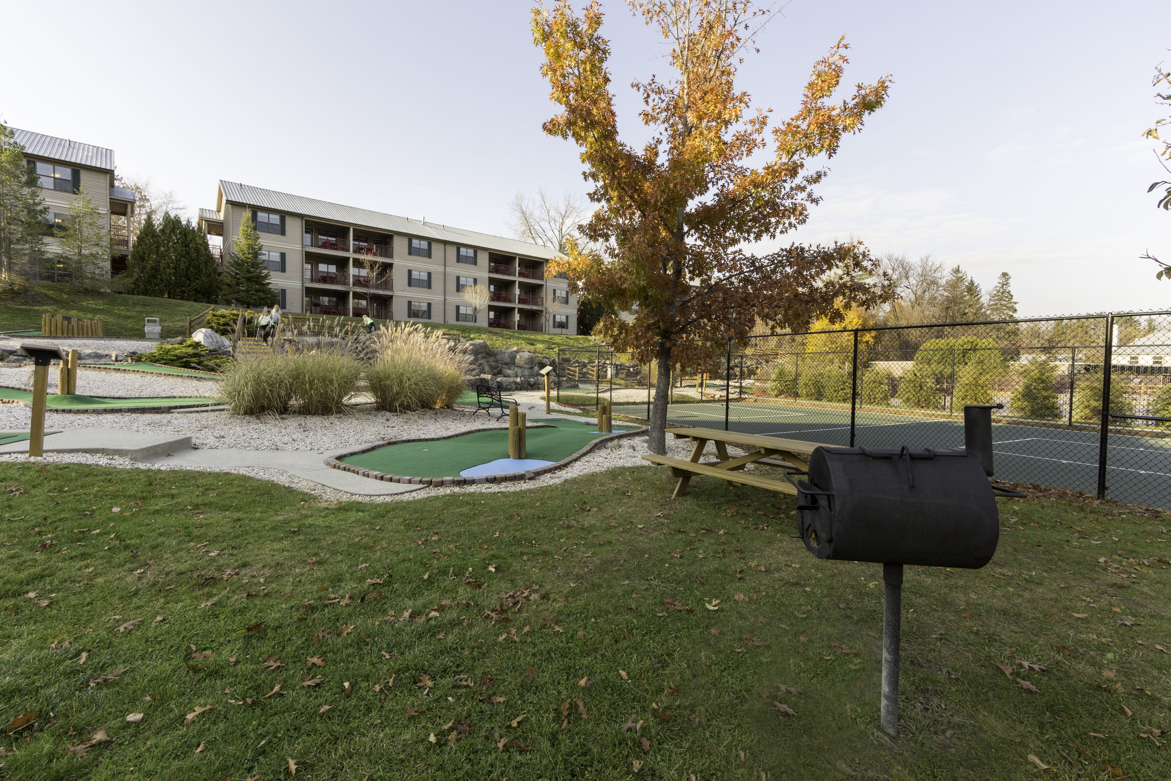 A courtyard with a pool table, a barbecue grill, and a mailbox.