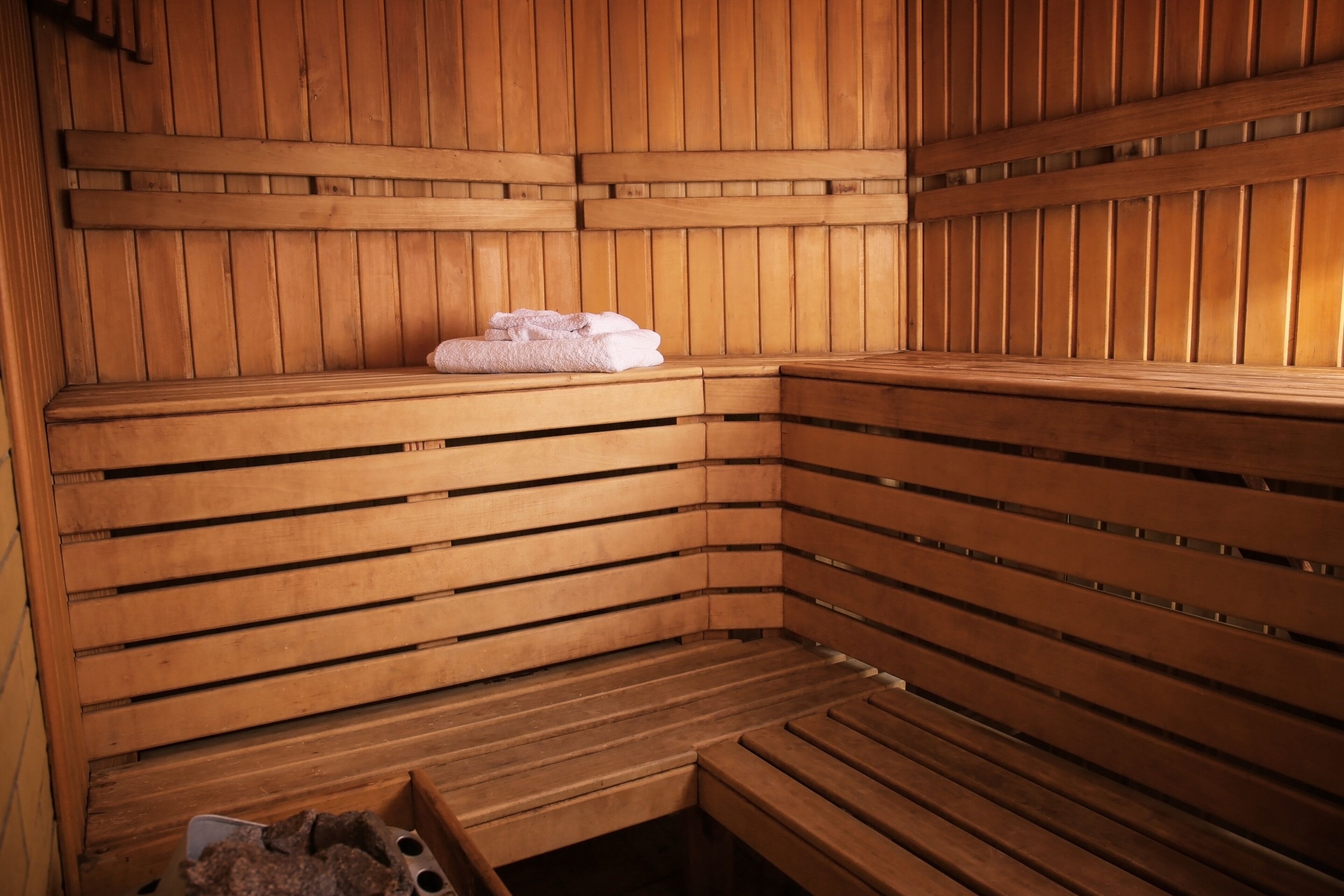 Una sauna in legno con panche e un asciugamano appoggiato su una di esse.