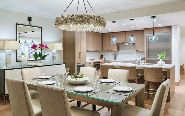 A modern kitchen with wooden cabinets, a central island, and pendant lighting.