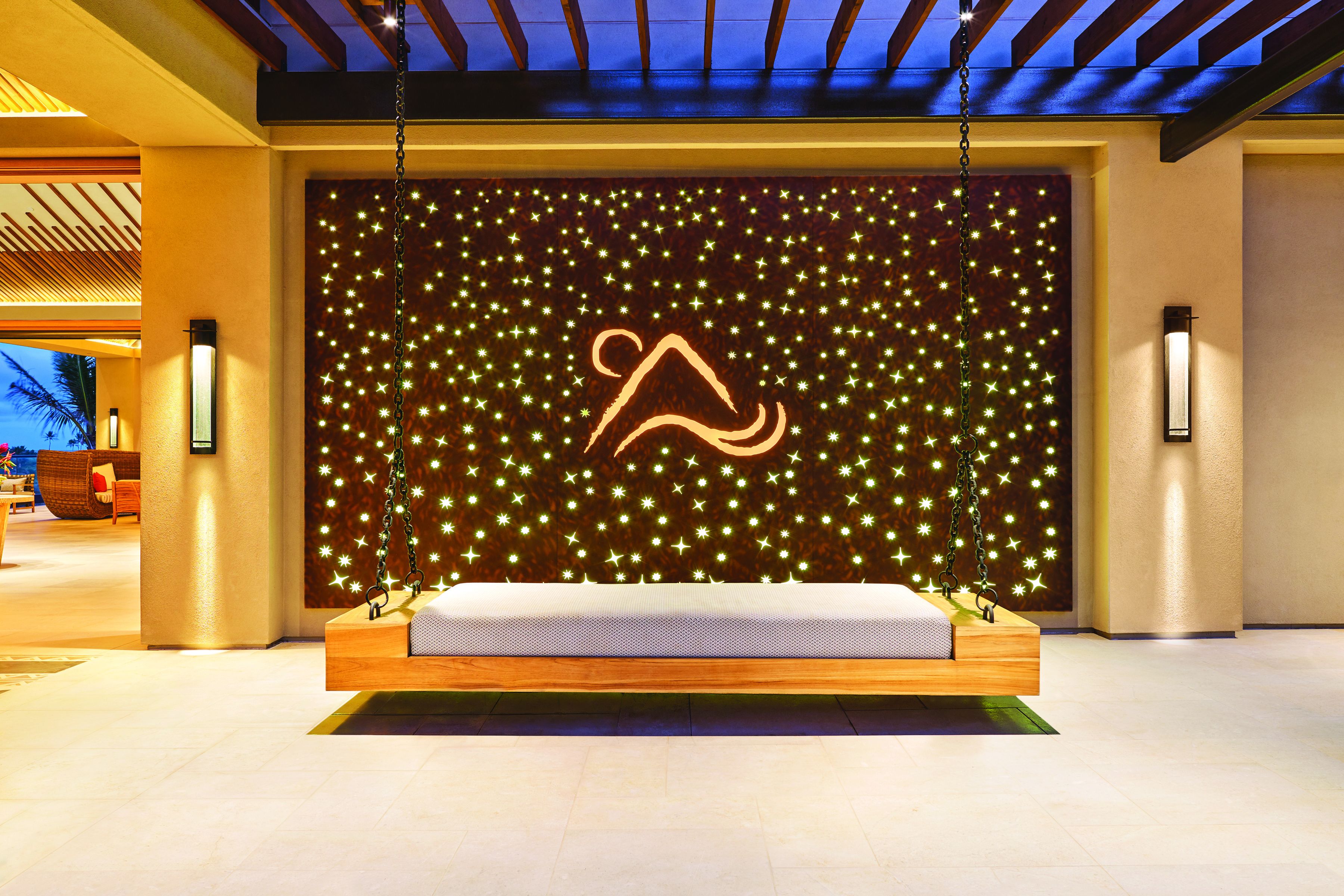Un vestíbulo moderno con una zona de estar central que presenta un diseño de pared iluminado único y un logotipo destacado.