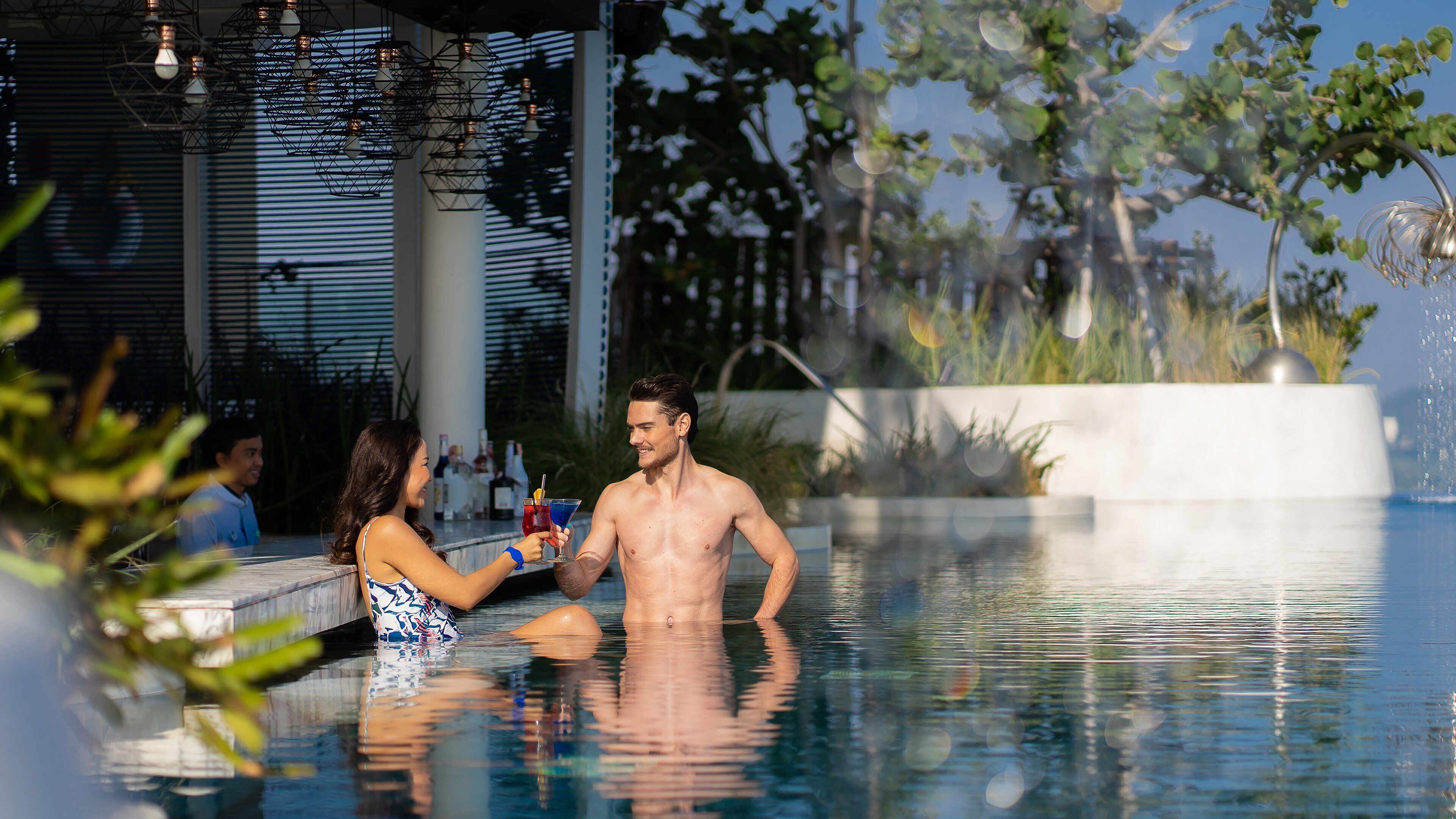 A man and a woman in a pool with a modern architectural background.