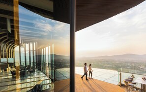 Un interior moderno con barandilla de cristal con vistas a un paisaje urbano.