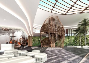 A modern lobby with a central seating area, a unique wooden structure, and a view of boats in the background. - Holiday Inn Resort Vana Nava Hua Hin by IHG (Hua Hin)