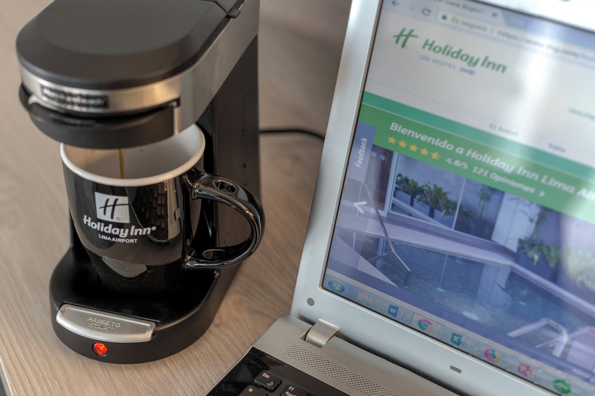 A laptop displaying a Holiday Inn webpage with a 4.5-star rating, a 121-room hotel, and a 4.6/5 overall rating.