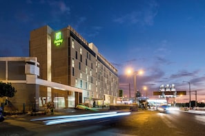 A Holiday Inn hotel with a modern facade, multiple floors, and a visible entrance.