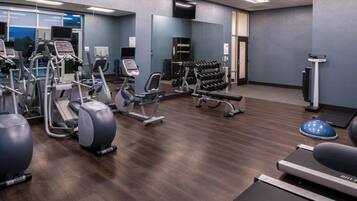 A gym with various exercise equipment, including treadmills, elliptical machines, and free weights.