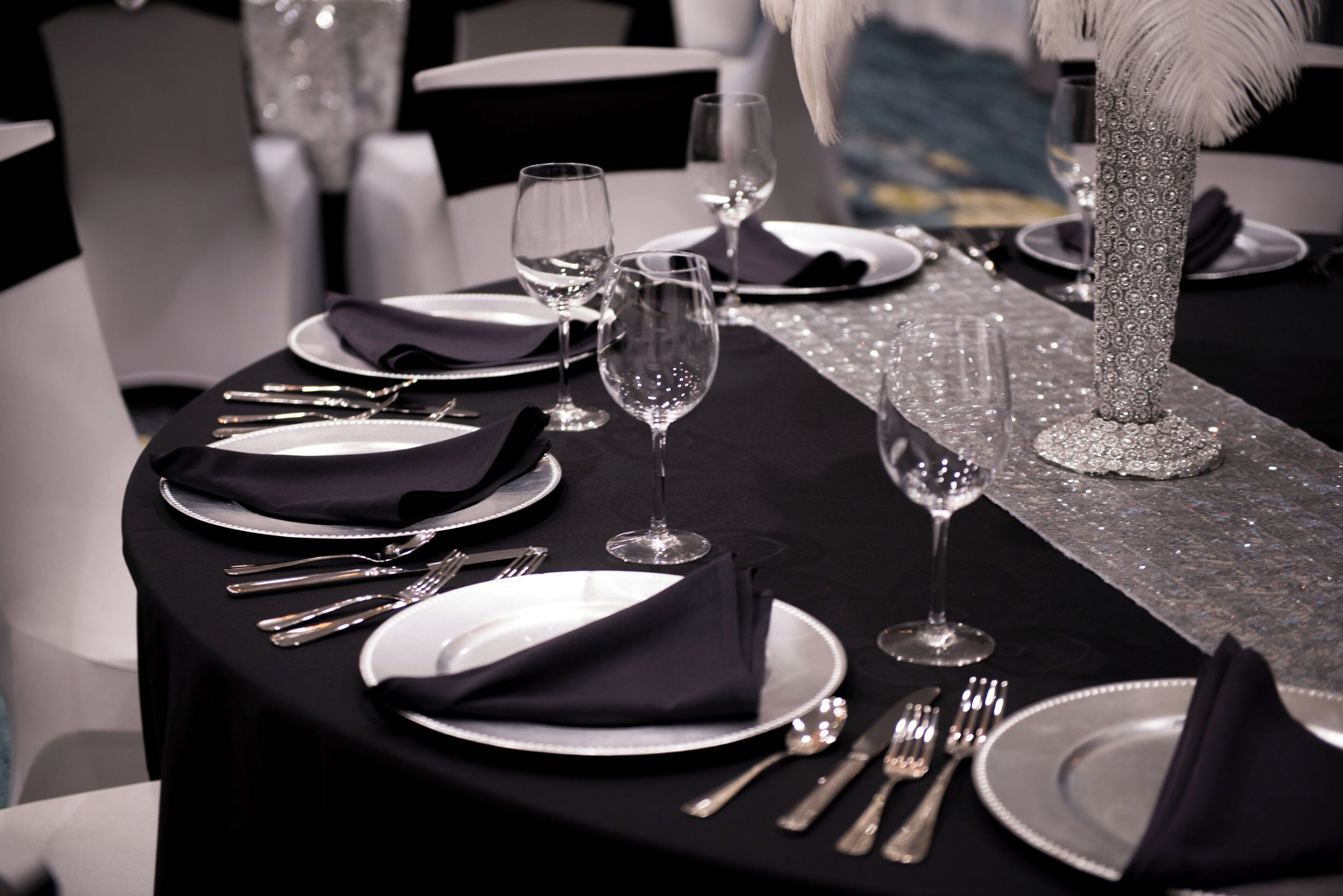 A table set for a formal dining occasion with plates, cutlery, and wine glasses.