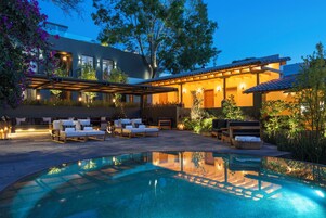 Una piscina al aire libre, sillones reclinables de piscina