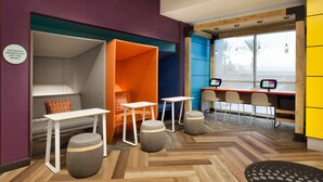 Una habitación moderna y colorida con una zona de estar, un escritorio y una computadora.