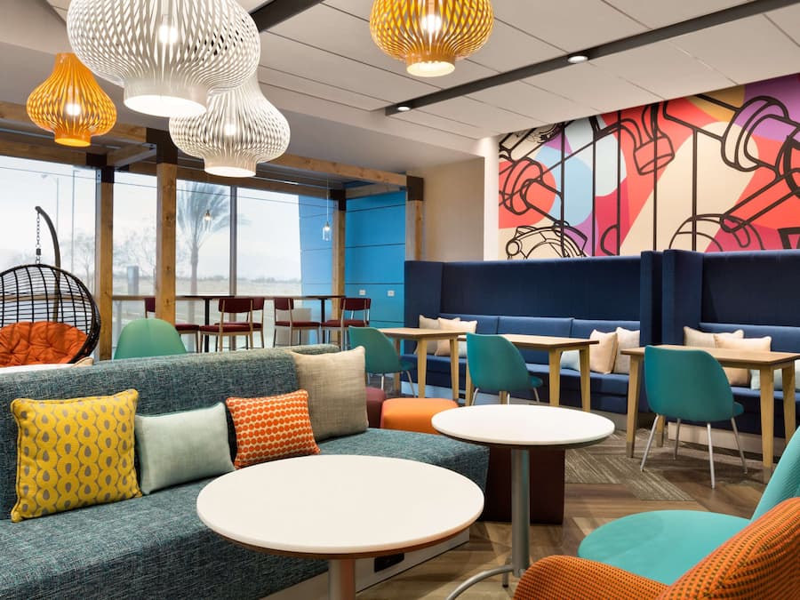 A modern lounge area with seating, tables, and hanging lights.
