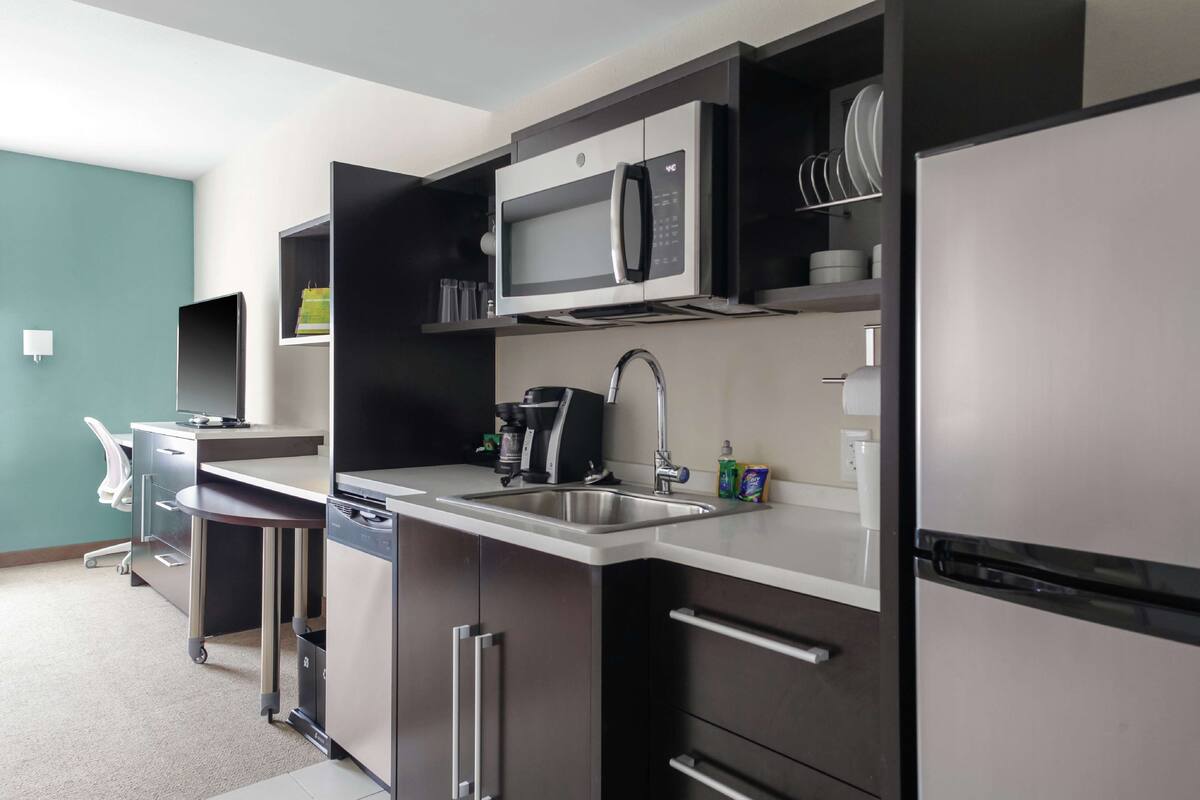 A modern kitchen with a microwave, coffee maker, and dishwasher.
