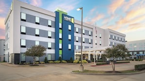 A modern hotel with a prominent "Home 2" sign, multiple floors, and a well-maintained outdoor area with landscaping. - Home2 Suites by Hilton Lake Charles, LA (Lake Charles)