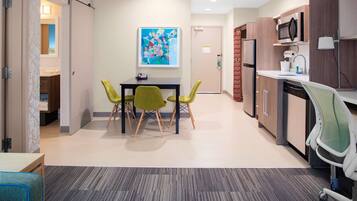 A modern kitchen with a microwave, sink, and dishwasher. There is a dining area with a table and chairs.