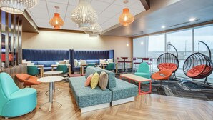 Un espace de détente moderne, doté de sièges, de tables et de luminaires suspendus.
