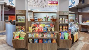 Un présentoir de collations dans un magasin, avec divers types de chips et d’en-cas.