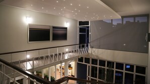 A multi-level interior with a staircase, a flat-screen TV, and a balcony with a view of the outside. - Casa Massima Hotel (León)