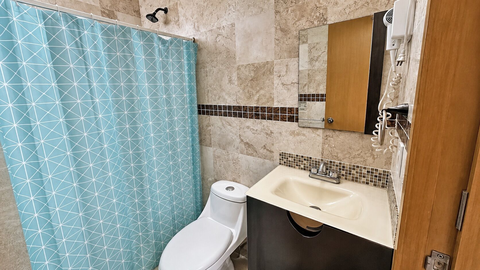 A bathroom with a toilet, a sink, and a shower curtain.