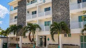 A multi-story hotel with a stone facade, balconies, and palm trees. - PUNTA ESMERALDA Hotel Boutique (Playa del Carmen)