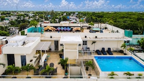 A rooftop pool area with lounge chairs, a pool, and a mural of hands. - PUNTA ESMERALDA Hotel Boutique (Playa del Carmen)