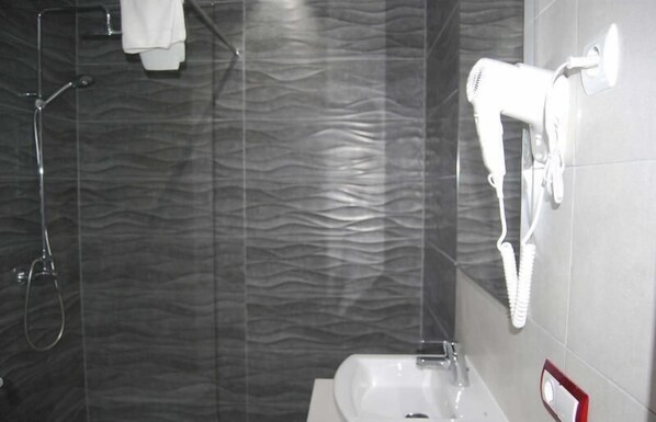 A bathroom with a shower, a hairdryer, and a sink. - Sol Naixent-bonaire (Felanitx)
