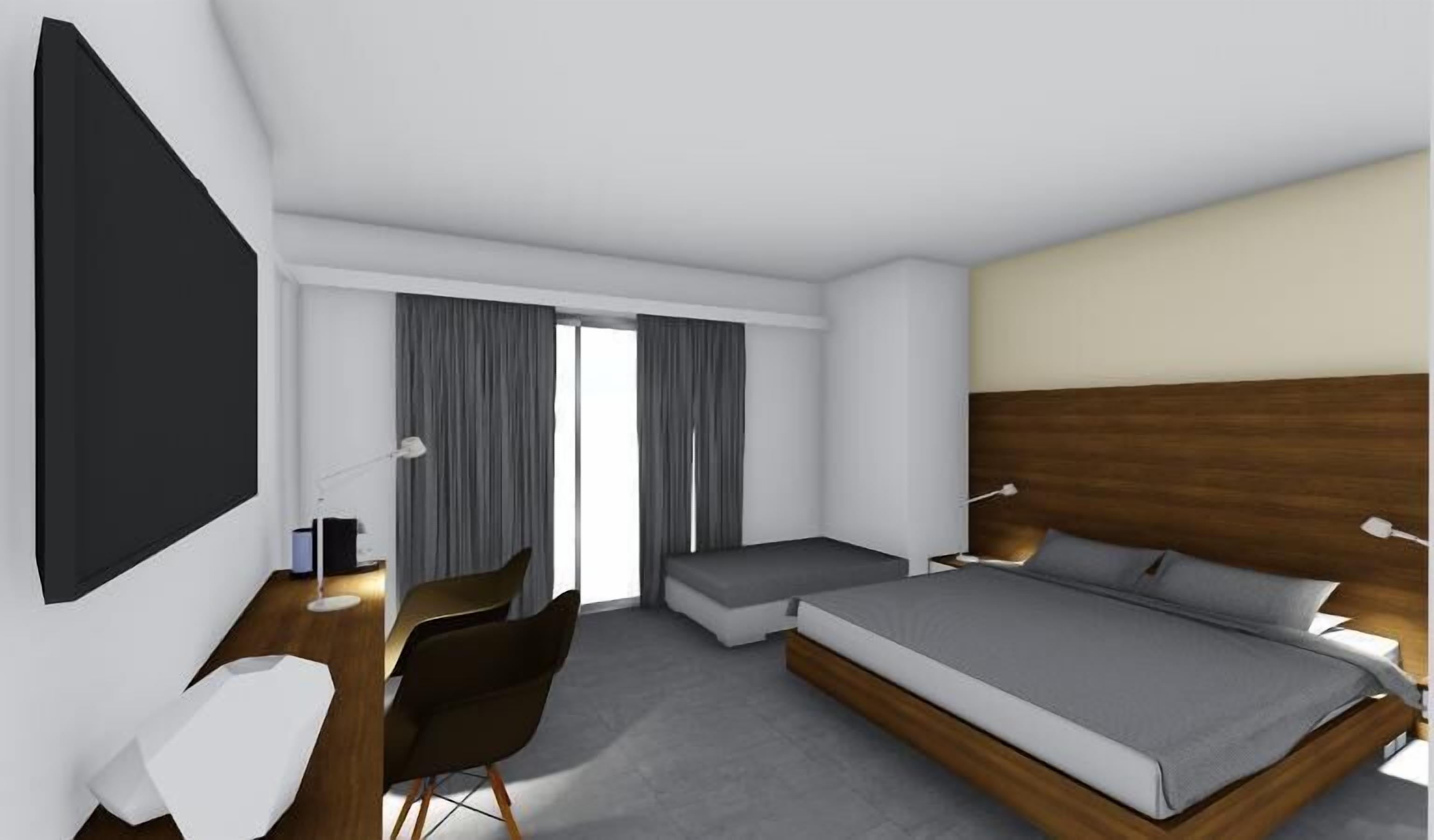 Habitació d'hotel moderna amb un llit gran, una taula de treball, una cadira i un televisor.