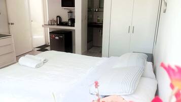 Una habitación de hotel con cama, kitchenette y armario.