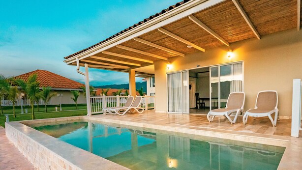 A swimming pool with lounge chairs, a covered patio, and a view of the surrounding landscape. - Bella Terra Laguna Azul Resort & Spa (Sauce)