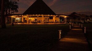 A building with a thatched roof, outdoor seating, and string lights. - Bella Terra Laguna Azul Resort & Spa (Sauce)