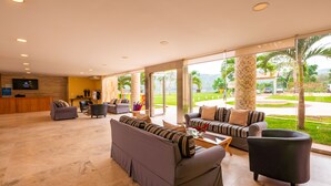 A spacious lobby with multiple seating areas, a reception desk, and large windows offering a view of the outdoors. - Bella Terra Laguna Azul Resort & Spa (Sauce)