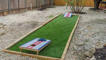 En baghave med et shuffleboardspil og et lille træ.