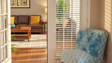 A living room with a sofa, a coffee table, and a patterned armchair.