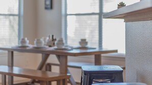 A dining area with a wooden table, benches, and a hanging light fixture.