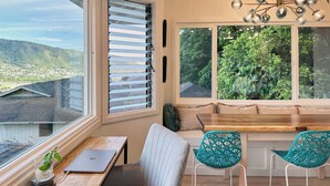 Een gezellig eetgedeelte met een houten tafel, een laptop en twee turquoise stoelen.