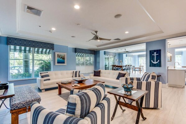 A spacious living room with a sofa set, a coffee table, and striped armchairs.